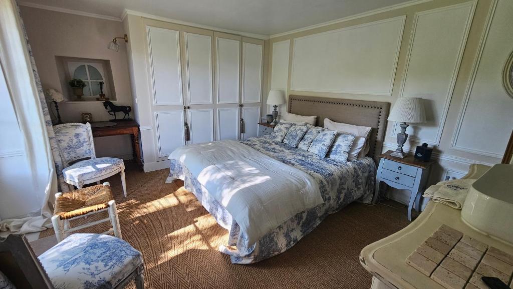 a bedroom with a bed and a desk and a chair at L'Orée d'Ermenonville in Borest