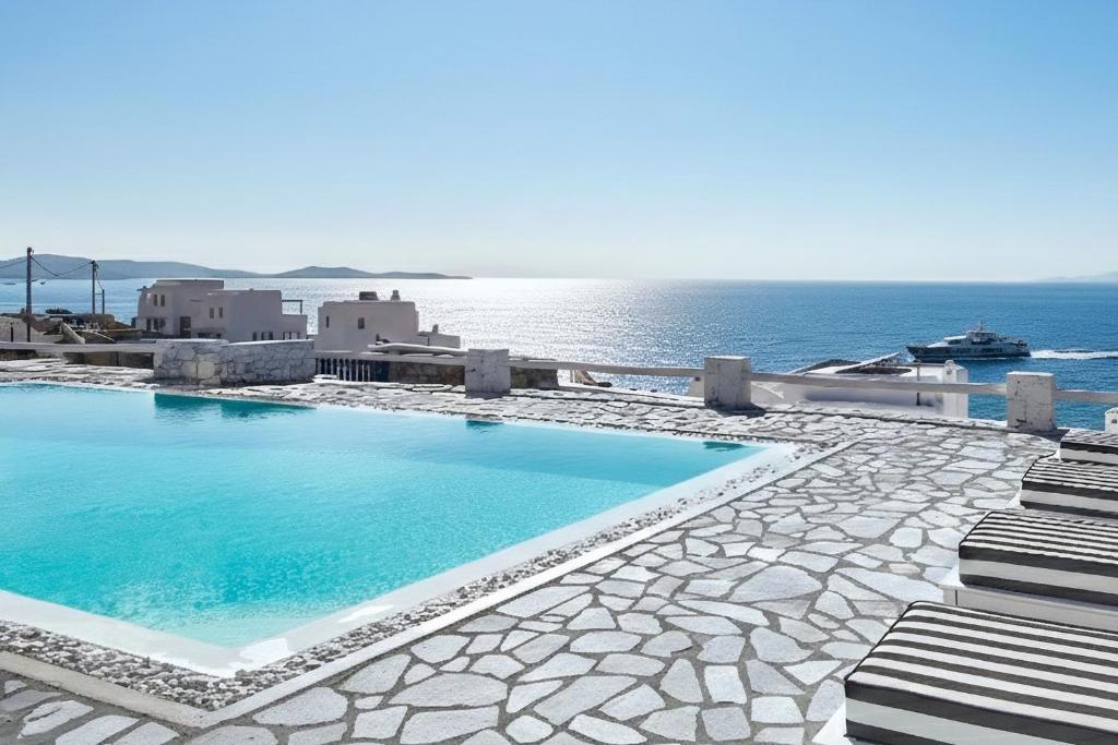 a swimming pool with the ocean in the background at MichaelAngelo Villa in Mikonos