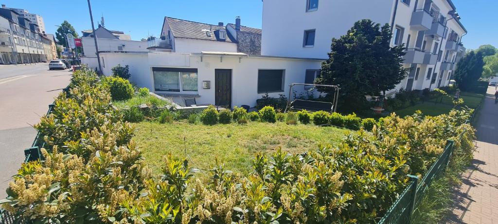 a garden in front of a house on a street at Maisonette mit Garten Bad Homburg in Bad Homburg vor der Höhe