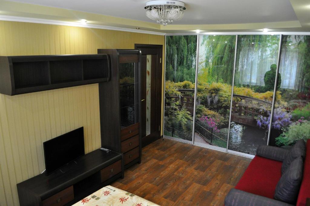 a living room with a large window with a garden at Apartment on Peace Avenue 84 in Mariupol