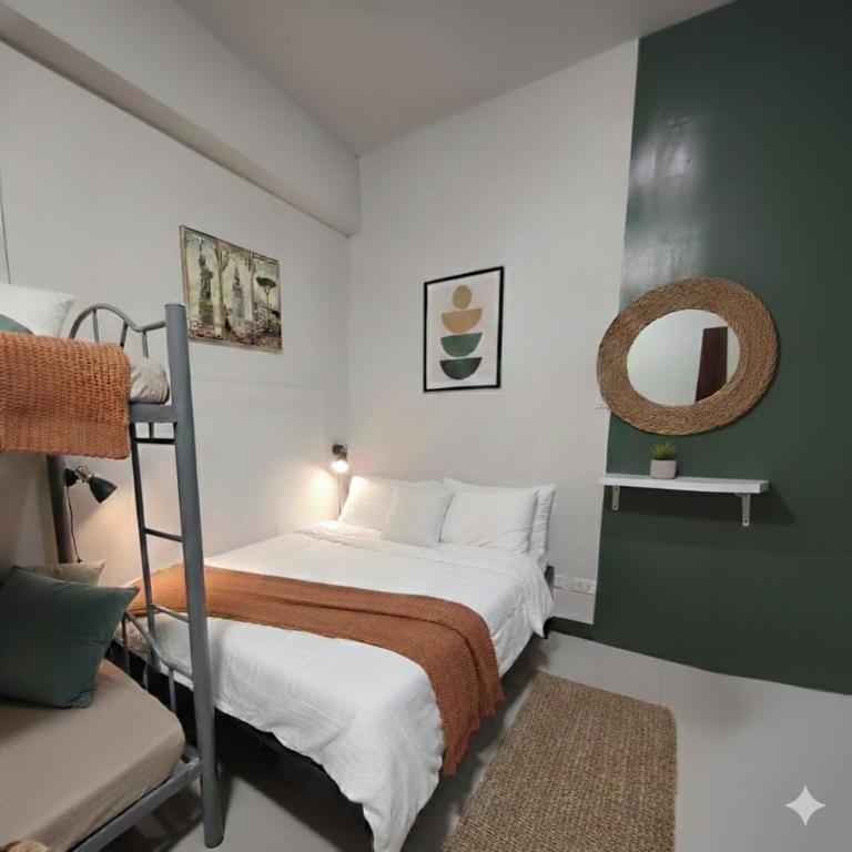 a bedroom with a bunk bed and a mirror at Ortigas Uptown Bonifacio CBD Hostel in Sampong