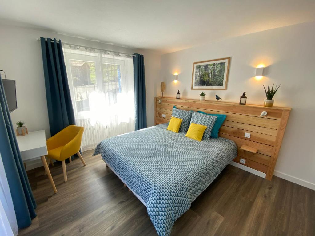a bedroom with a bed with blue and yellow pillows at Ardeche2coeur in Marcols-les-Eaux
