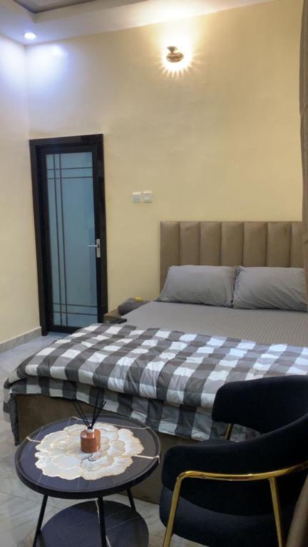 a bedroom with a bed and a table and chairs at Crystal Apartment in Ofada