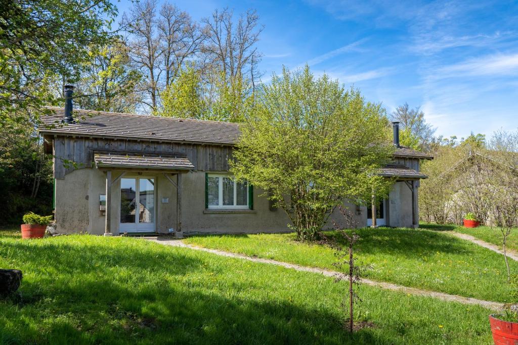 a small house in a yard with green grass at Gite Fontaine in Le Soulié
