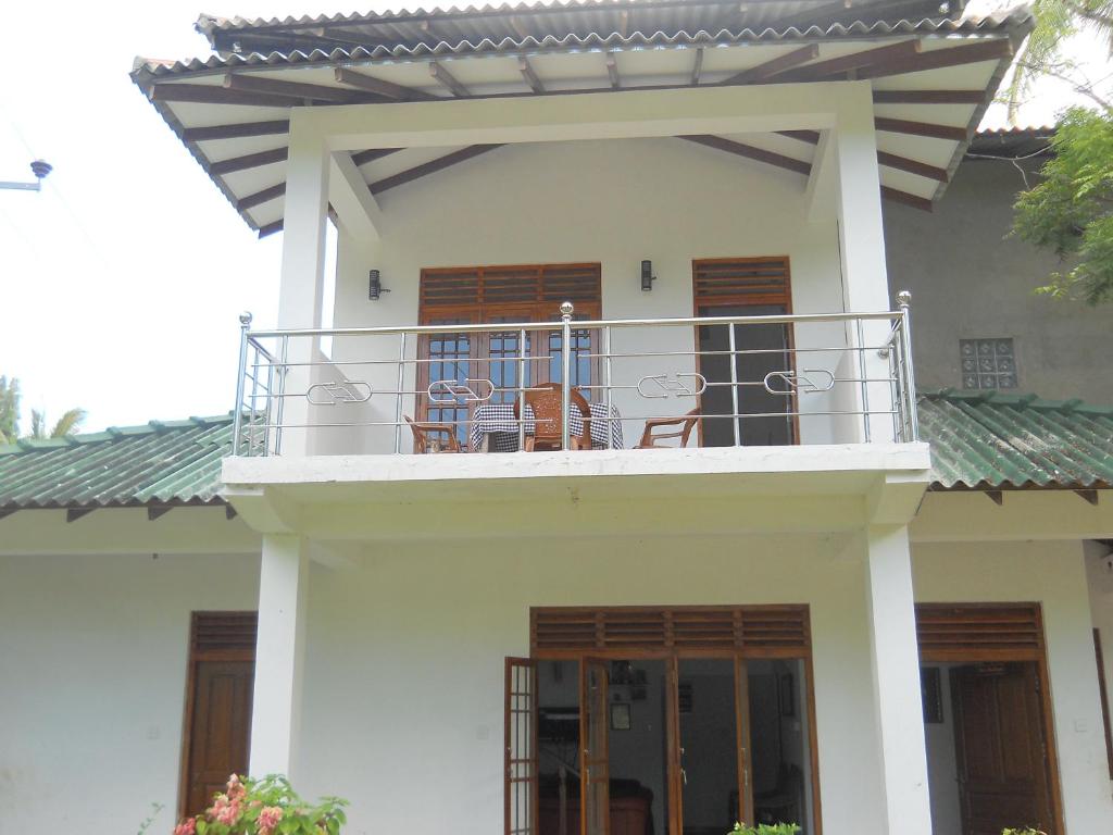Casa con balcón con sillas. en Sunset Tourist Home en Polonnaruwa