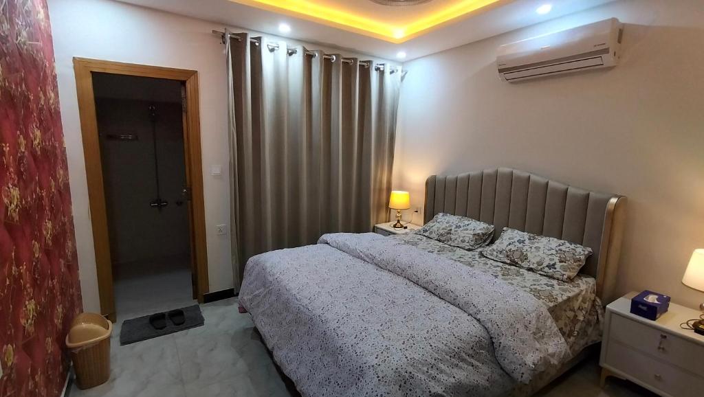 a bedroom with a bed and a door to a bathroom at 2 BHK Starry Night Penthouse in Islamabad