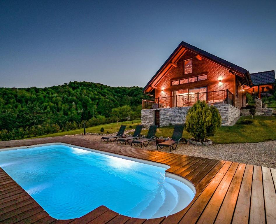 a house with a swimming pool in front of a house at Casa Kapusta, Hidden gem in nature, Swimming poll, Jacuzzi, Fire Pit in Ogulin
