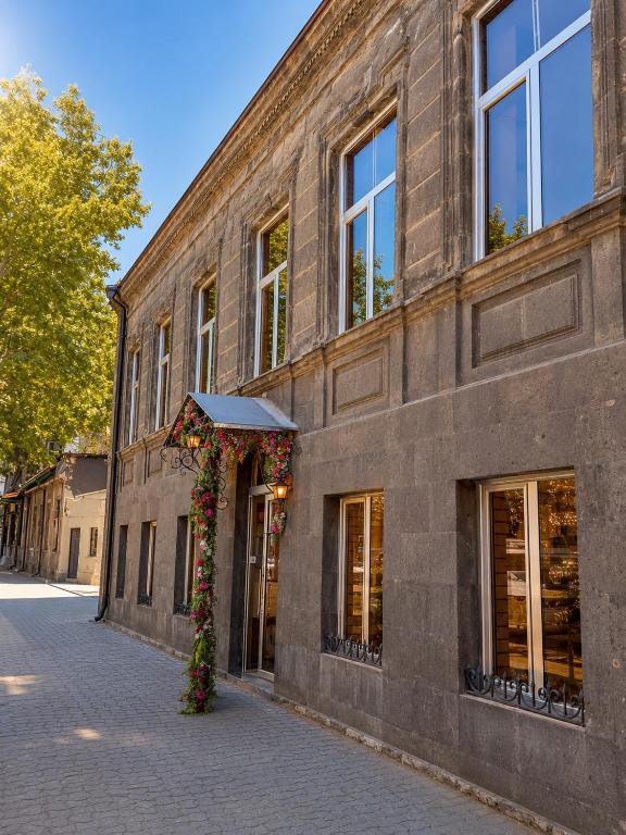 a brick building with a doorway with flowers on it at Mini hotel in centre in Yerevan