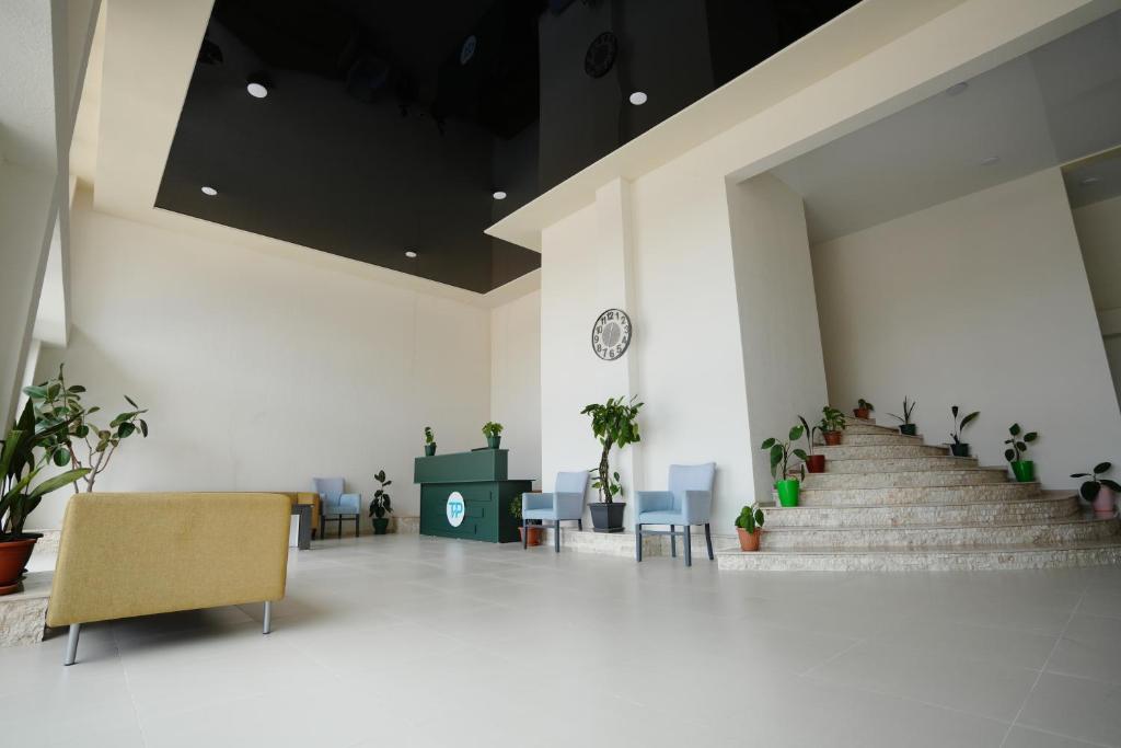 a lobby with stairs and a clock on the wall at Toma Palace in Makhinjauri