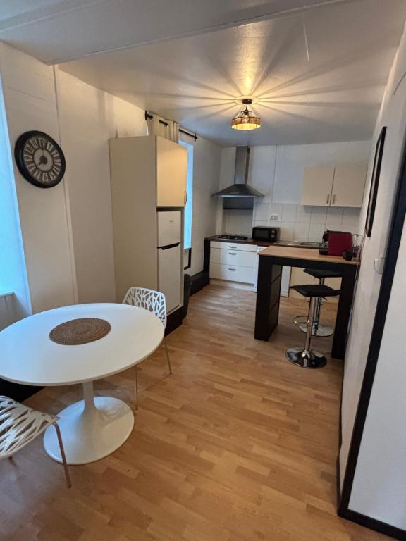 a small kitchen with a white table and a table and chairs at Domino in Vaucouleurs