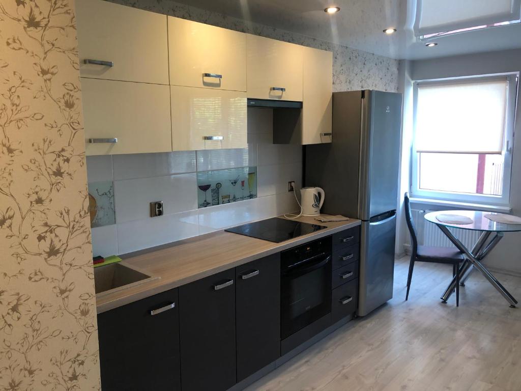 a kitchen with black cabinets and a sink and a table at Seaside Park in Liepāja