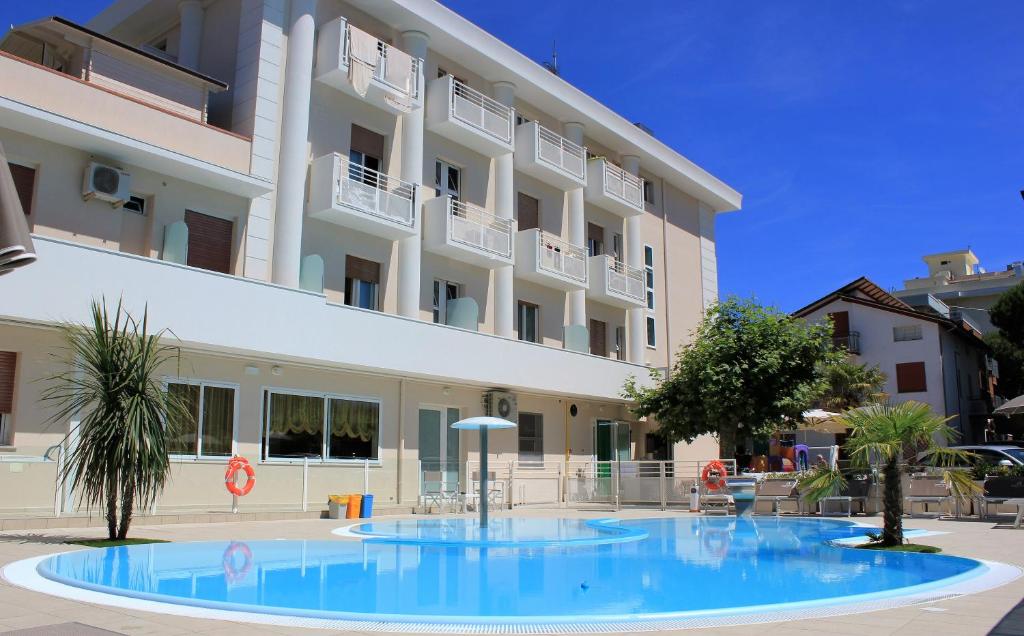 una grande piscina blu di fronte a un edificio di Hotel Bella Igea a Bellaria-Igea Marina