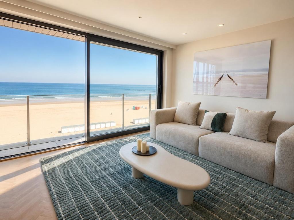 a living room with a couch and a table at Knokke Sea, Appartement Vue mer in Knokke-Heist