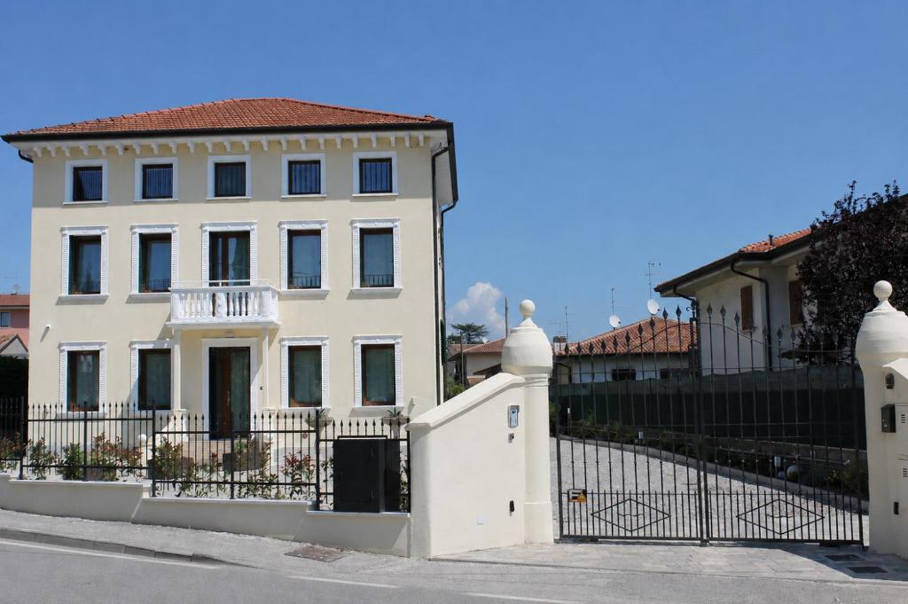 a white house with a gate and a fence at Villa Ander in Colà di Lazise