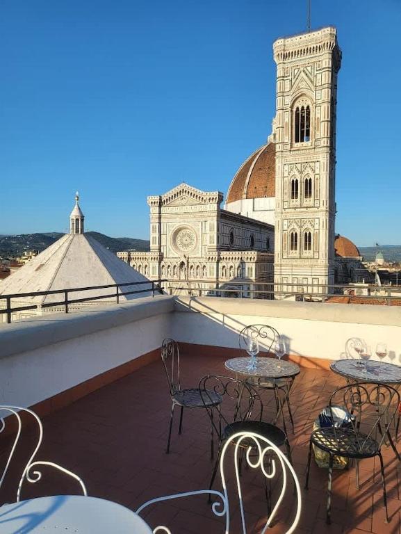 a balcony with tables and chairs in front of a building at Spacious 2BR with 2 Ensuite Baths in Florence in Florence