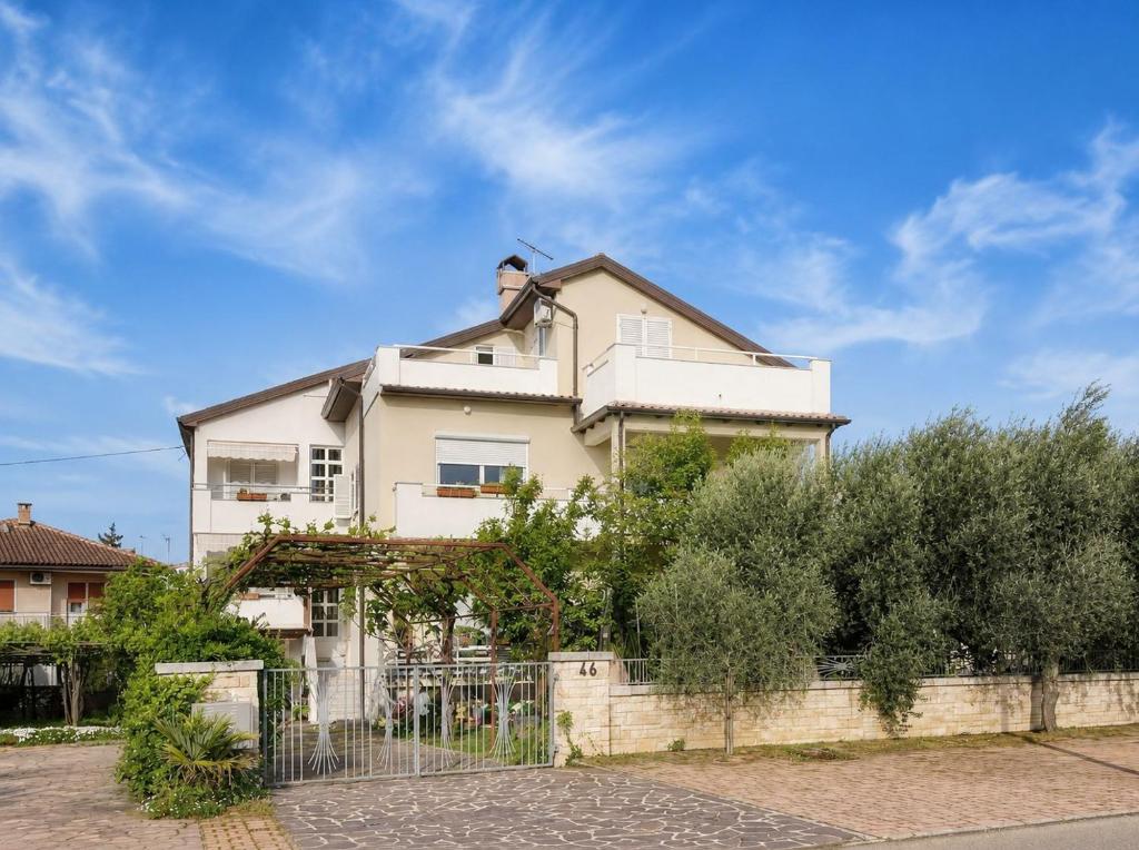 a white house with a fence in front of it at Apartments Maria in Umag