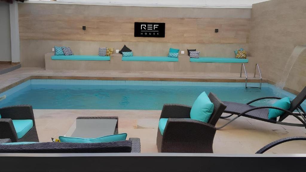 a swimming pool with chairs and a table at REF House Barra Da Tijuca in Rio de Janeiro