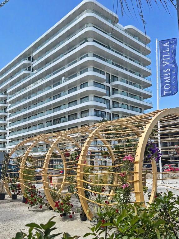 a large white building with a large sculpture in front of it at Tomis Villa Grand Resort in Mamaia Sat/Năvodari