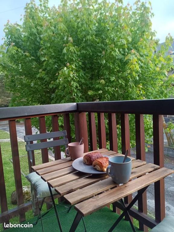 a wooden table with a plate of food on a balcony at Appartement Vignec proche Saint-Lary in Vignec