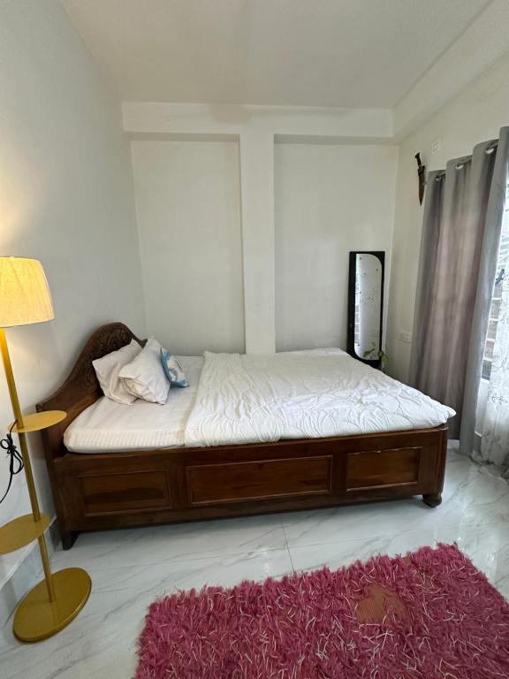 a bedroom with a bed and a red rug at SS Hostel in Siliguri