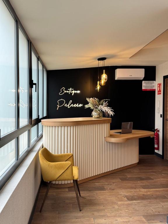 a restaurant with a yellow chair and a counter at Boutique Palacio in Alicante