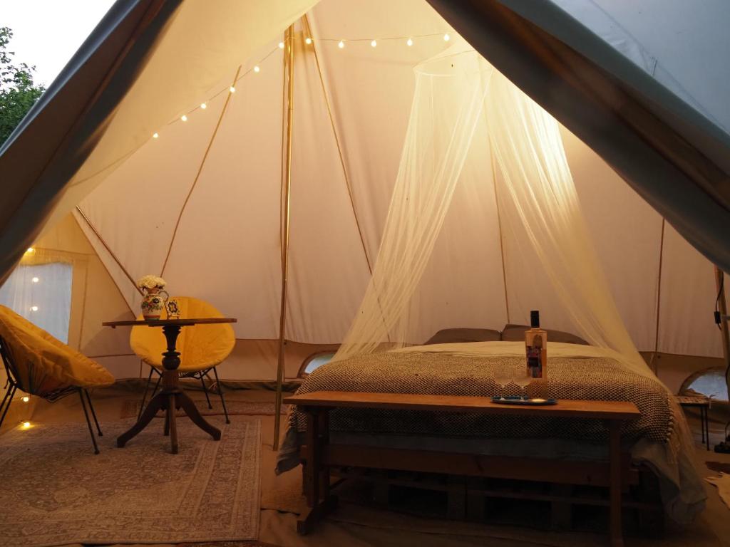 a bedroom with a bed in a tent at Glamping Tent Celte du Morvan, Vrij in de Natuur in La Tagnière