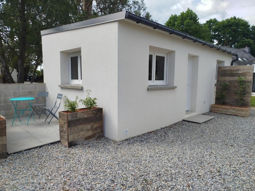 a white house with a table and a patio at Petite maison meublée in Landévant