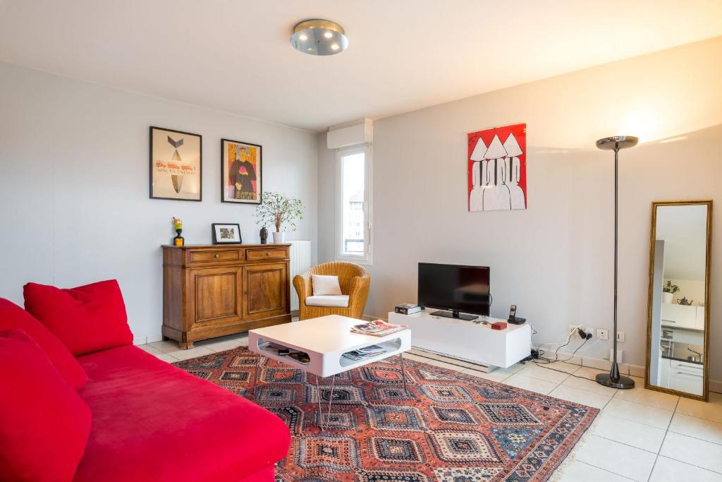 ヴィルールバンヌにあるMaisons Neuves/Montchatのリビングルーム(赤いソファ、テーブル付)