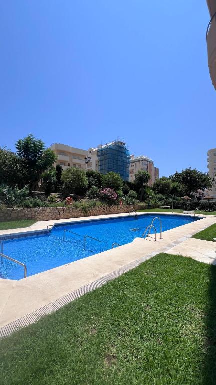 a large swimming pool in the middle of a city at Bright Flat 1 min from Beach with parking in Fuengirola