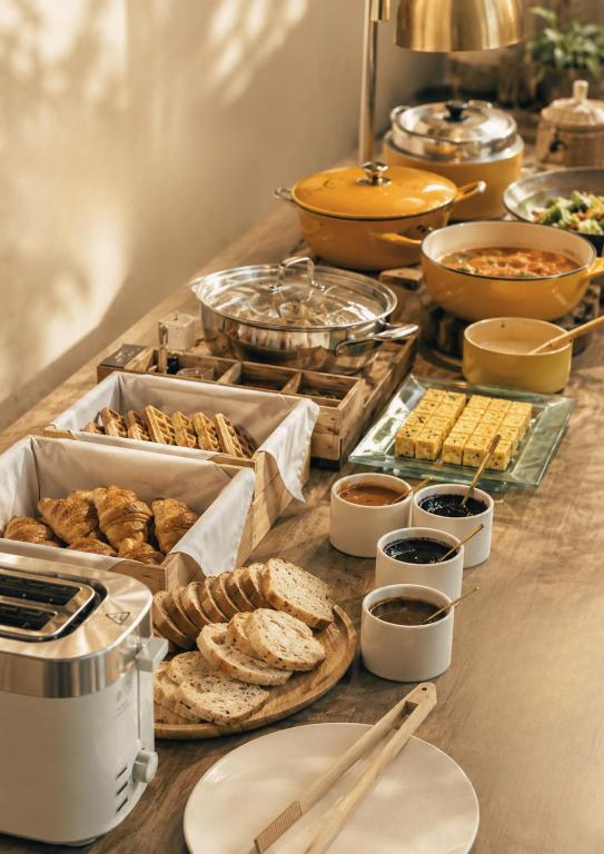 A buffet counter offering breads, spreads, hot dishes, fruit, and drinks.