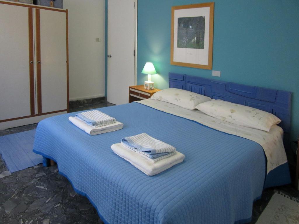 ペスカーラにあるHoliday Home Pescaraの青いベッドルーム(タオル付きのベッド付)