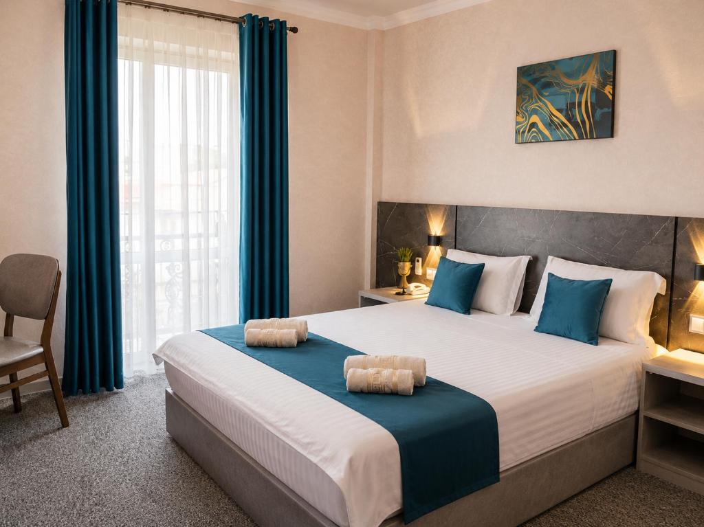 a bedroom with a large bed with blue accents at Boston Hotel Tashkent in Yakkasaray
