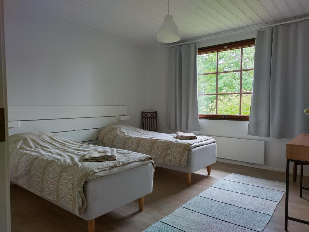 a bedroom with two beds and a window at Kuivasjärvi House in Oulu