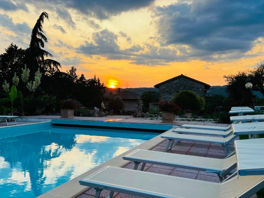 a pool with lounge chairs in front of a sunset at Casa Jasmine by Lisetta in Migiana