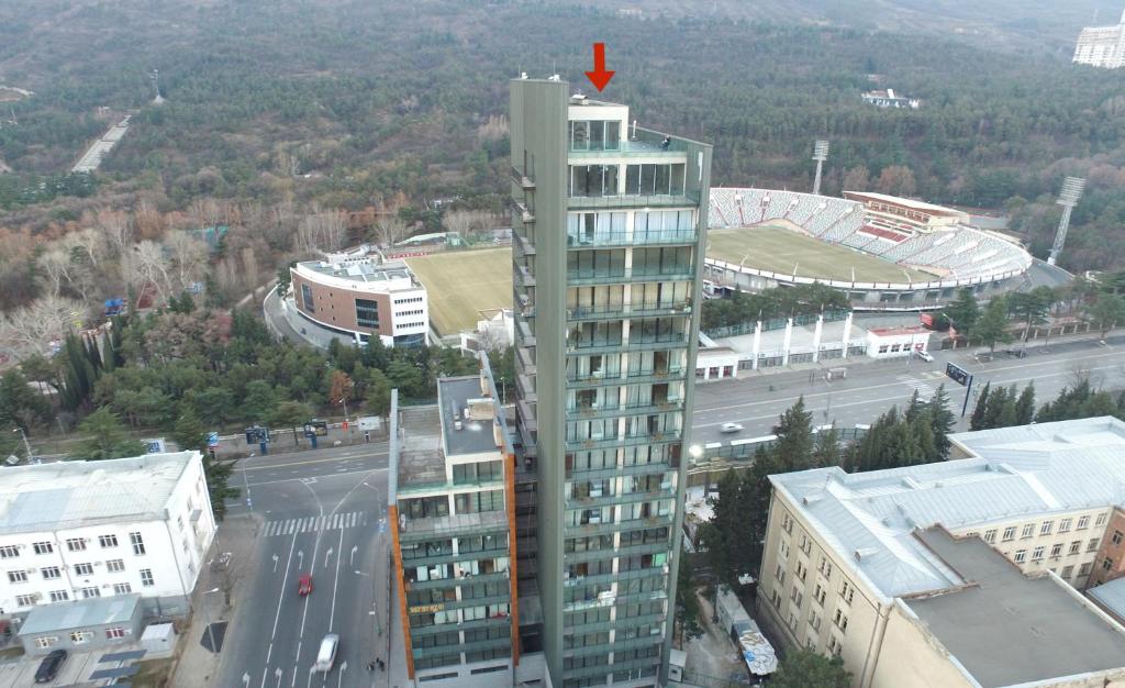 un edificio alto con una flecha roja encima en Full Comfort Apartment at Chavchavadze en Tiflis