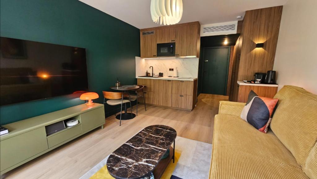 a living room with a couch and a kitchen at Studio Golfe Juan bord de mer - parking & piscine in Vallauris
