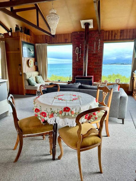 a living room with a table and two chairs at Kakanui Surf Bach in Kakanui