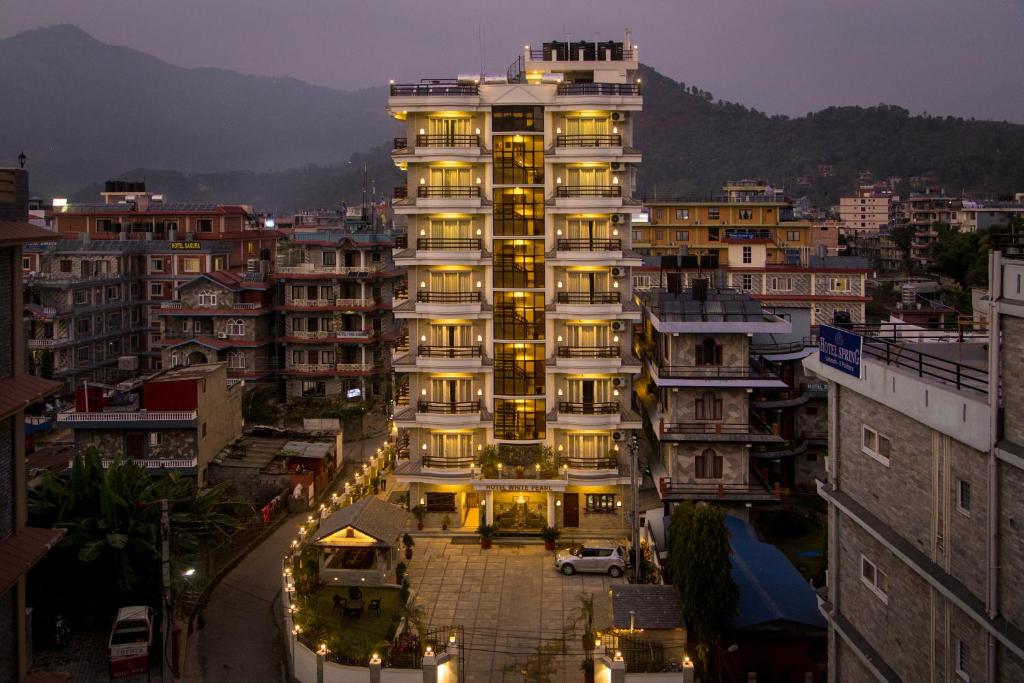 a tall building with lights in a city at Hotel White Pearl in Pokhara