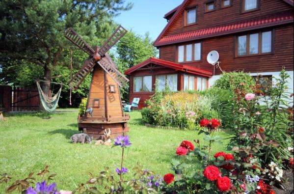a windmill in a yard next to a house at Domek Pod Skansenem in Białowieża