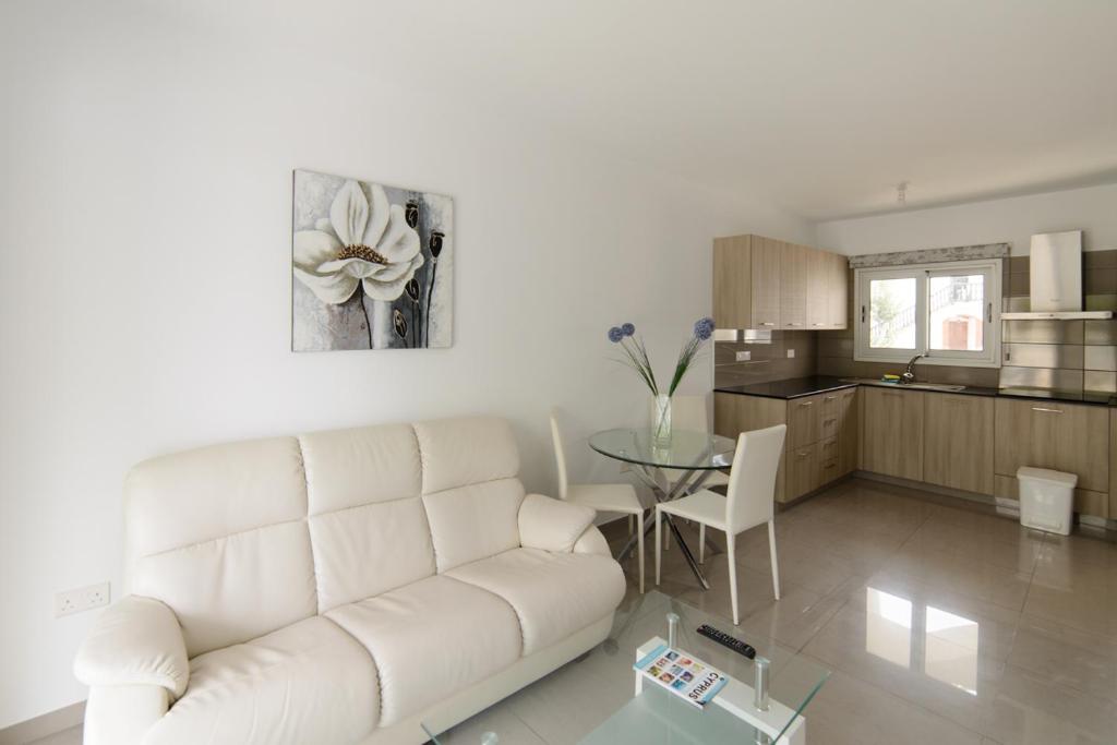 アヤナパにあるKatalimata Courtの白いソファとテーブルのあるリビングルーム