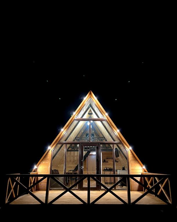 a pyramidangular building with a glass facade at night at Сади Вітрів in Oriv