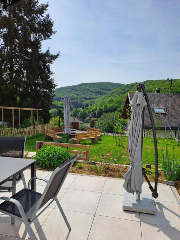 a patio with a table and chairs and an umbrella at Ferienwohnung Hahnenblick in Hahnenbach