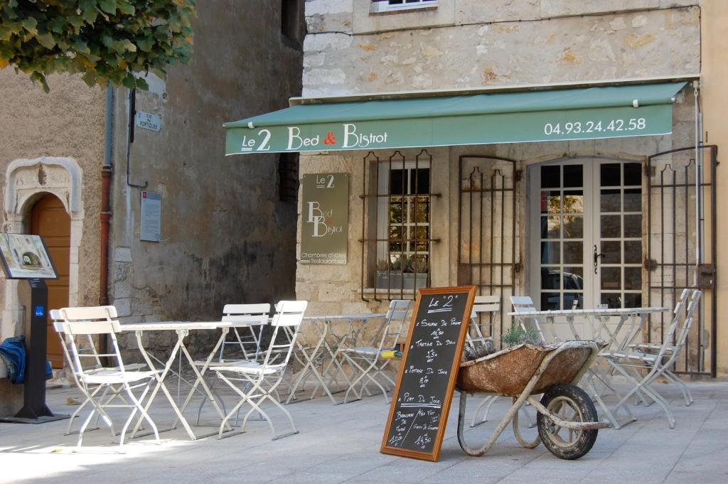 a restaurant with a table and chairs and a sign at Le 2 in Vence