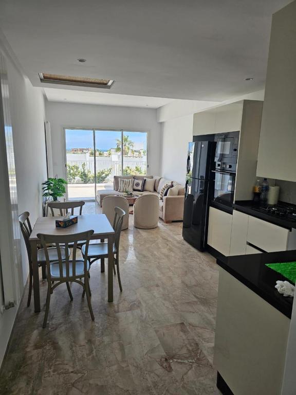 a kitchen and living room with a table and chairs at Penthouse sarra in Kelibia