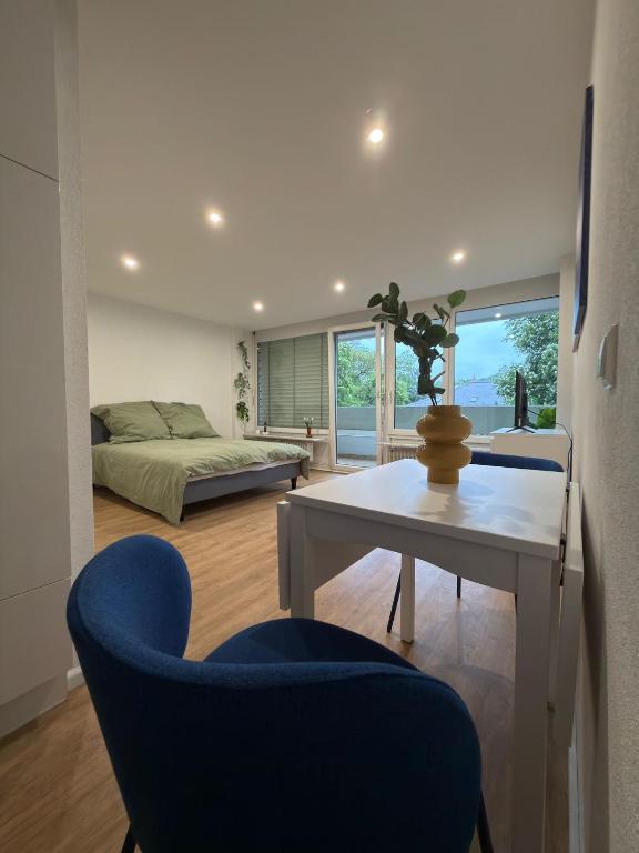 a living room with a bed and a blue chair at City Apartment in Lörrach