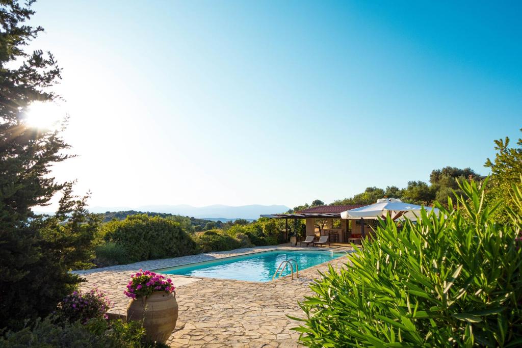 a swimming pool in a yard with a house at The Englishman's Villa Evia in Perivólia