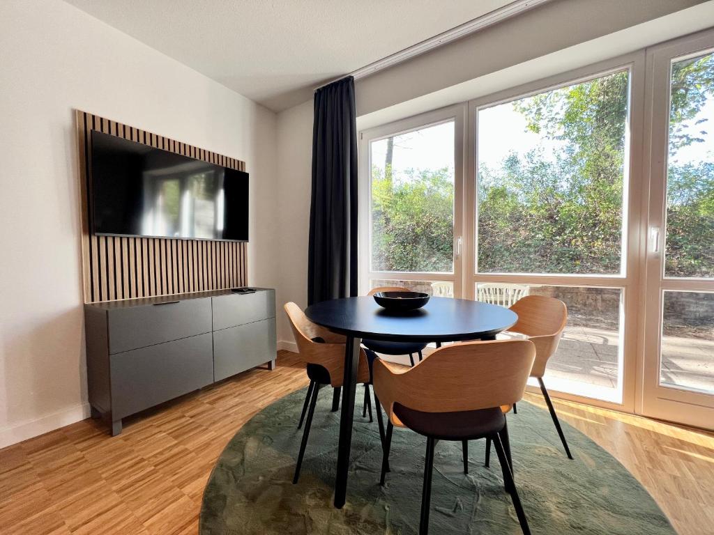 a dining room with a table and chairs and a tv at apments - Premium Apartments nahe Hamburg in Rosengarten