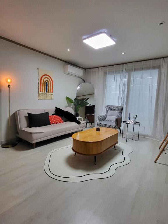 a living room with a couch and a coffee table at 씨하우스 501호 in Hakch'ŏn-dong