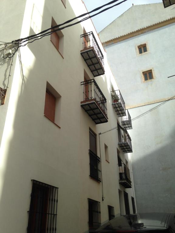 un edificio blanco con balcones en un lateral en Hostal Aranda, en Peñíscola