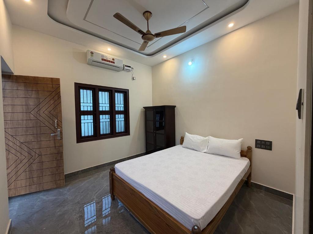 a bedroom with a bed and a ceiling fan at Tri Riverfront Homestay in Udupi